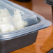 A Genpak black rectangular plastic container filled with food.