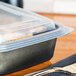 A Genpak clear plastic rectangular lid on a plastic container with food in it.