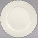 A Fineline Flairware ivory plastic plate with a scalloped edge.