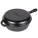 A black cast iron pot with a lid inside a black cast iron skillet.