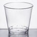 A clear Fineline Savvi Serve hard plastic shot glass on a white surface.
