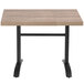 A Grosfillex VanGuard weathered oak resin table top on a table with black legs.