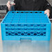 A chef holding a blue plastic Carlisle glass rack with extenders.