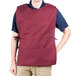 A man wearing a burgundy Intedge cobbler apron with two pockets.