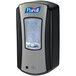 A black and silver Purell® LTX hand sanitizer dispenser on a wall.