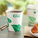 A close-up of an EcoChoice leaf print paper hot cup filled with coffee on a table.