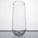 A WNA Comet clear plastic stemless flute on a white surface.