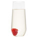 A WNA Comet clear plastic stemless flute filled with a liquid and a raspberry.