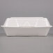 A white styrofoam container with a hinged lid.