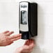 A person using a GOJO chrome soap dispenser.