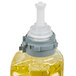 A close up of a GOJO bottle of yellow liquid hand soap with a white lid.