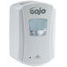 A white GOJO® touchless soap dispenser with a clear window.
