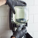 A person in black gloves putting GOJO liquid into a dispenser.