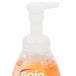 A bottle of GOJO foaming hand soap with a white cap and orange liquid with a GOJO logo.