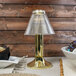 A Sterno Paige Polished Brass lamp on a table in a breakfast diner.