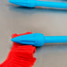 A blue plastic tip on a red piece of fabric.