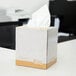A white Choice 2-ply facial tissue cube on a desk.