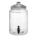 An Acopa clear glass beverage dispenser with a black lid and tap.