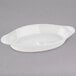 A Tuxton white oval dish with a handle.