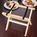 A Tablecraft wooden mini table tray stand with a natural finish holding plates of pizza on a table.