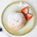 A Carlisle round melamine bread and butter plate with a pastry and strawberries on it.