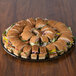 A Solut black catering tray of sandwiches on a table.