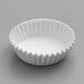A white fluted mini baking cup on a white surface.