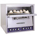 A Bakers Pride countertop pizza oven with a tray of pies inside.