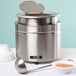 An Avantco stainless steel round food warmer with a spoon and bowl on a countertop.