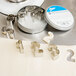 A container of Ateco stainless steel number cookie cutters on a table.