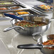 A Vollrath induction pan with food in it on a countertop.