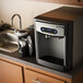 A Follett countertop ice maker and water dispenser with a blue and white screen over a sink.