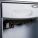 A black and silver Follett 7 Series water dispenser with a built-in ice maker and filter.