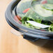 A clear Fineline plastic flat lid on a salad bowl.