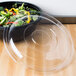 A Fineline clear plastic lid on a bowl of salad.