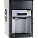 A black and white Follett countertop ice maker and dispenser with a blue screen.