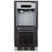 A black and silver Follett 7 Series undercounter ice maker and water dispenser with a water filter and clear glass door.