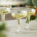 Visions clear plastic champagne glasses filled with champagne on a table in a catering event.