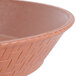 A close up of a terracotta round plastic fast food basket with a woven pattern.