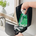 A hand using Kutol Health Guard Vanilla Essence hand soap from a green bag