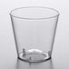 A clear plastic Choice shot glass on a white surface.