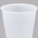 A Dart translucent plastic cup with a white lid on a gray surface.
