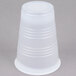 A white Dart plastic cup with a black lid on a gray surface.