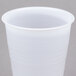 A Dart Conex plastic cup with a white lid on a gray surface.