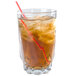 An Arcoroc highball glass of iced tea with a straw.
