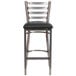 A clear-coated metal restaurant barstool with a ladder back and black vinyl seat.