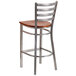 A Clear-Coated metal restaurant barstool with a cherry wood seat.
