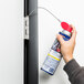 A person using WD-40 EZ-Reach Spray Lubricant to spray a door handle.