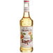 A bottle of Monin Premium Amaretto Flavoring Syrup with a label.