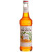 A bottle of Monin Premium Candied Orange Fruit Syrup on a white background.